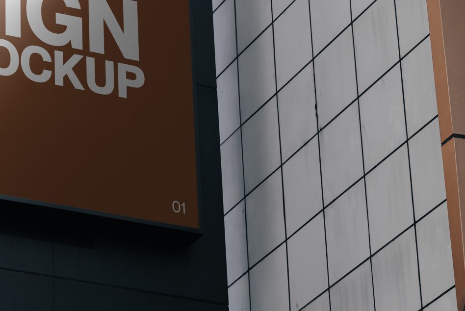 Close-up corner view of brown panel with partial mockup text, gridded white facade section beside it