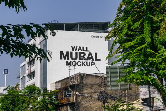 Urban wall mural mockup on building exterior with lush green foliage for realistic design presentation, ideal for graphic designers.