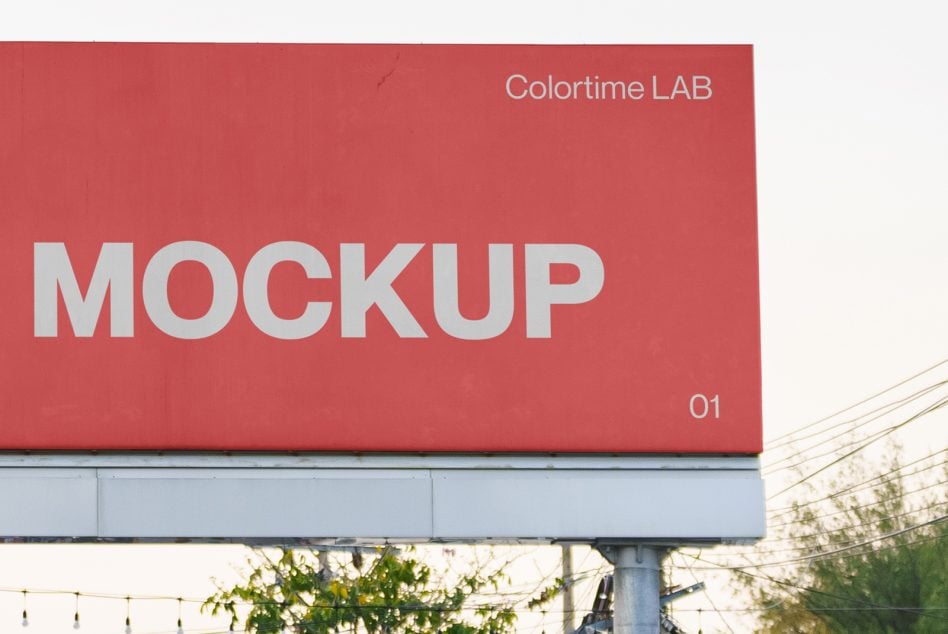 Red billboard with white text on quiet street with power lines overhead