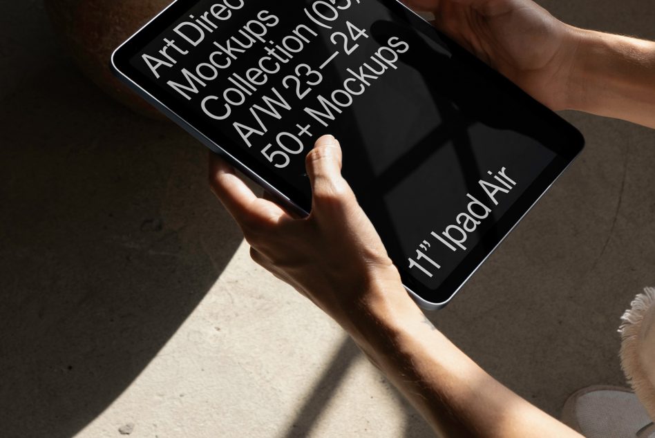 Person holding a tablet displaying a digital mockup for an Art Direction Mockups Collection, suitable for designers and presentations.