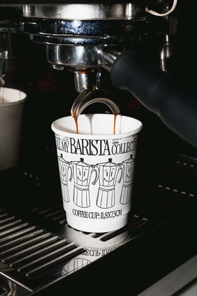 Espresso pouring into a graphic printed coffee cup from a machine, ideal for mockups in beverage and cafe branding design.