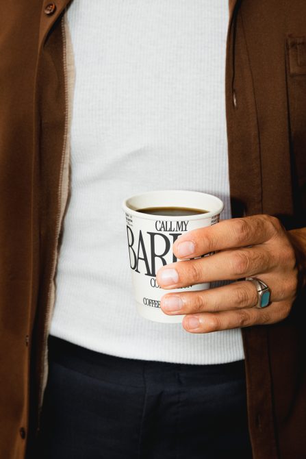 Person holding a mug with bold typography design, ideal for mockup template, showcasing font styles and branding elements for designers.