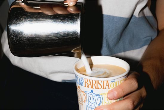 Barista pouring milk into coffee cup creating latte art, perfect for mockup graphics in cafe branding design projects.