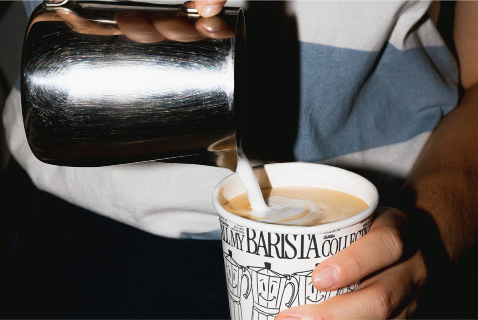 Barista pouring milk into coffee cup, creating latte art, close-up. Perfect for mockup design with a cafe or urban lifestyle theme.