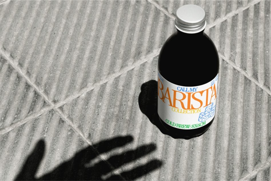 Colorful Barista Collection cold brew bottle on concrete with hand shadow visible