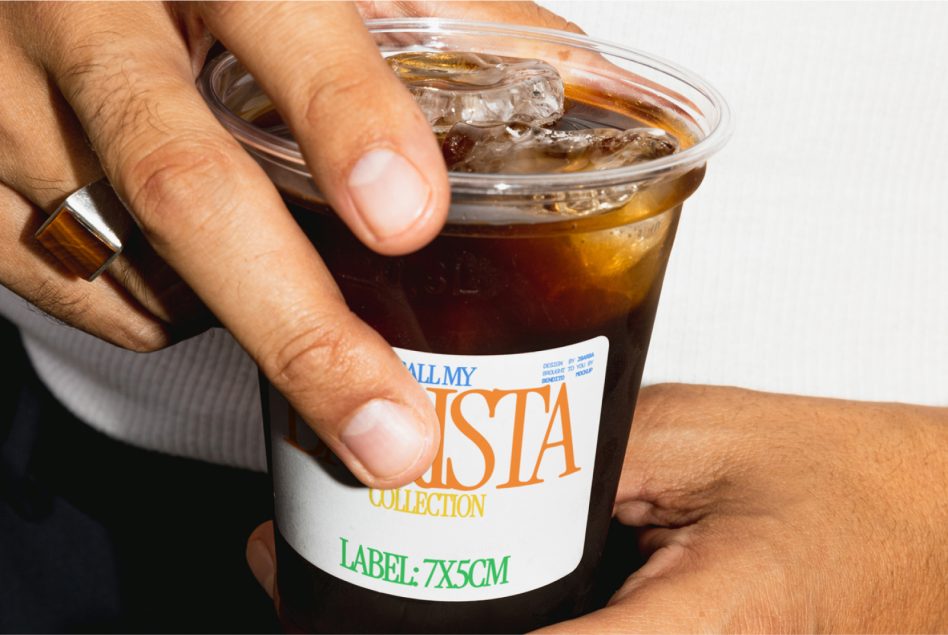 Close-up of hands holding iced coffee cup mockup with editable label, perfect for beverage branding presentations, design showcase.