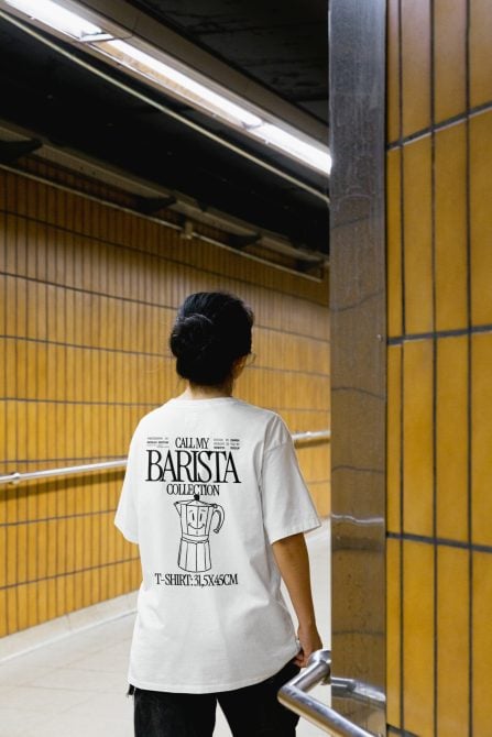 Person in subway station wearing white t-shirt with graphic design, ideal for apparel mockup templates, trendy urban style.