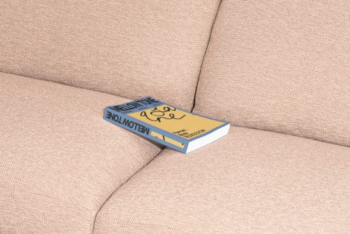 Realistic book mockup on textured sofa for presentation, showcasing design cover, digital asset perfect for designers, book mockup template.