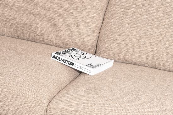 Book mockup on beige sofa, clean design magazine template, editable digital asset for graphic presentation, realistic texture.