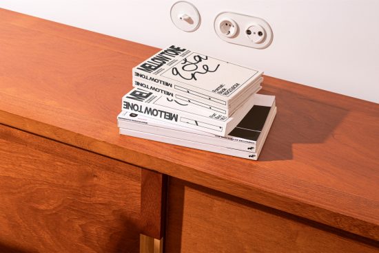 Stack of magazines mockup on wooden table next to wall with power outlets, realistic shadows, perfect for display, layout design showcase.