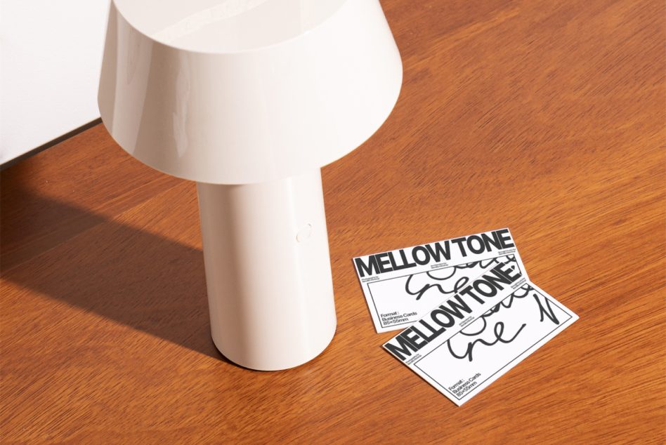 Minimalist white lamp beside stacked Mellow Tone business cards on timber