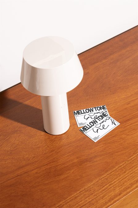 White mushroom lamp with two Mellow Tone business cards on wooden table