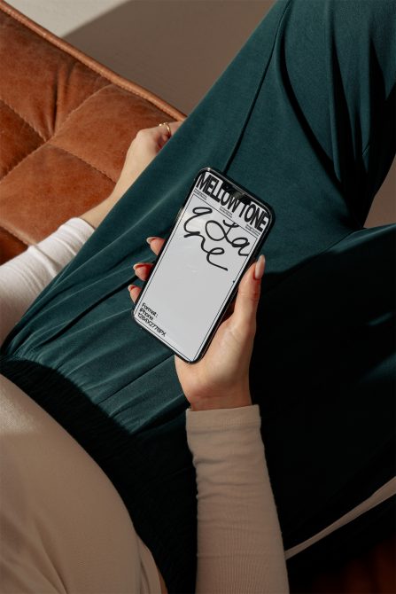 Person holding smartphone showcasing script font design, ideal for Templates and Mockups category, displaying stylish typography for branding.