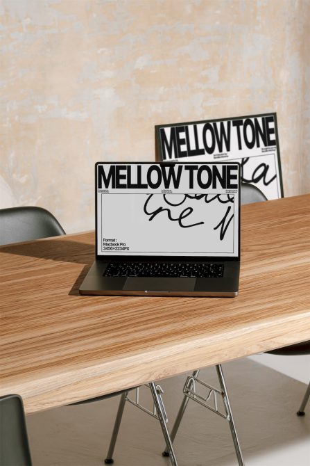 Laptop on wooden table displaying font design mockup in a workspace setting, suitable for graphic design, branding, and typography presentations.