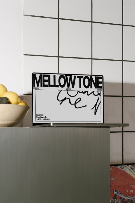 Modern laptop mockup on kitchen counter with stylish calligraphy and resolution details for digital design asset display.