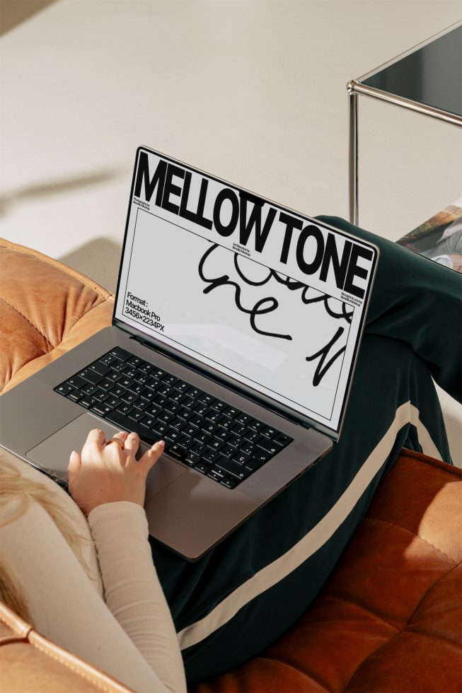 Person using a laptop displaying font design Mellowtone, perfect for designer mockups, graphic templates, and creative font showcases.