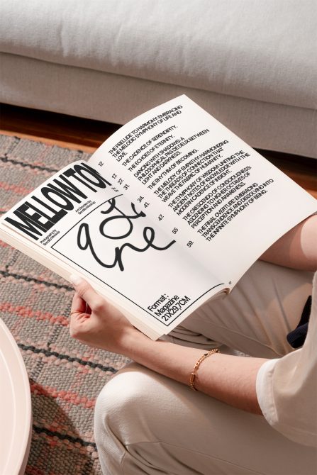 Person holding an open magazine featuring stylish typography design, ideal for mockup, graphic design inspiration, and font showcase.