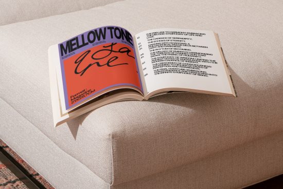 Open book on a beige sofa showcasing stylish font design on vibrant orange cover, interior design mockup perfect for designers' presentations.