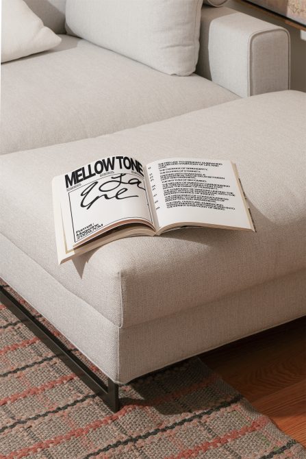 Open magazine mockup on beige sofa with visible text design, ideal for presentation in graphics and templates category.