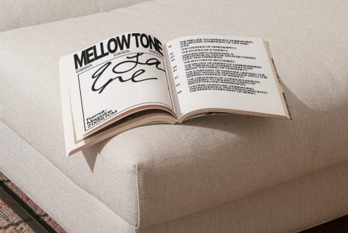 Open magazine mockup on textured couch showcasing elegant font design and layout, perfect for presentations, design assets.