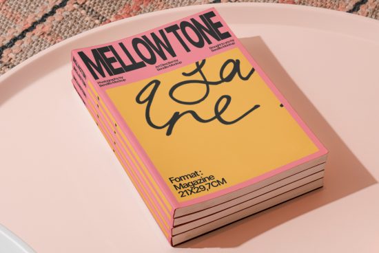 Magazine mockup on pink surface with bold typography design, showcasing page layout for brand identity and graphic design elements.