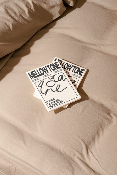 Multiple stacked white notebook mockups on beige fabric with natural shadows