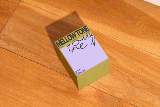 Yellow product packaging mockup with elegant overlay shadow on wooden surface, displaying Mellowtone graphics for product design presentation.