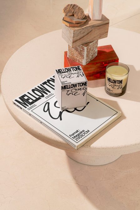 Elegant magazine mockup on terrazzo table with modern decor and candle, showcasing custom font and design layout for graphic designers.