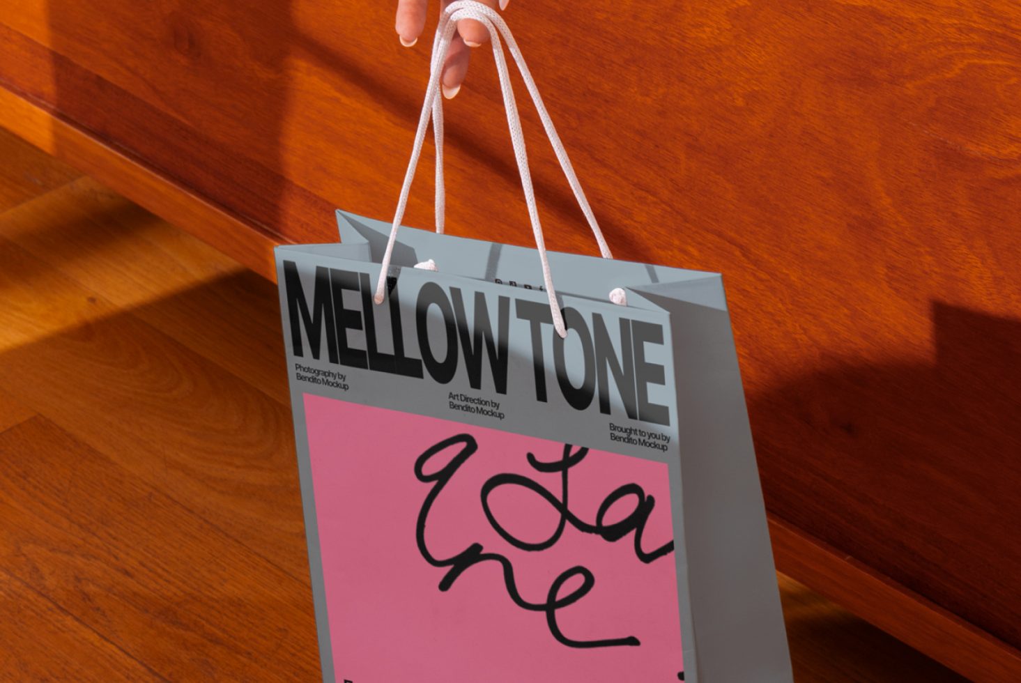 Hand holding a shopping bag mockup with modern typography design, ideal resource for graphic presentations in retail and branding.