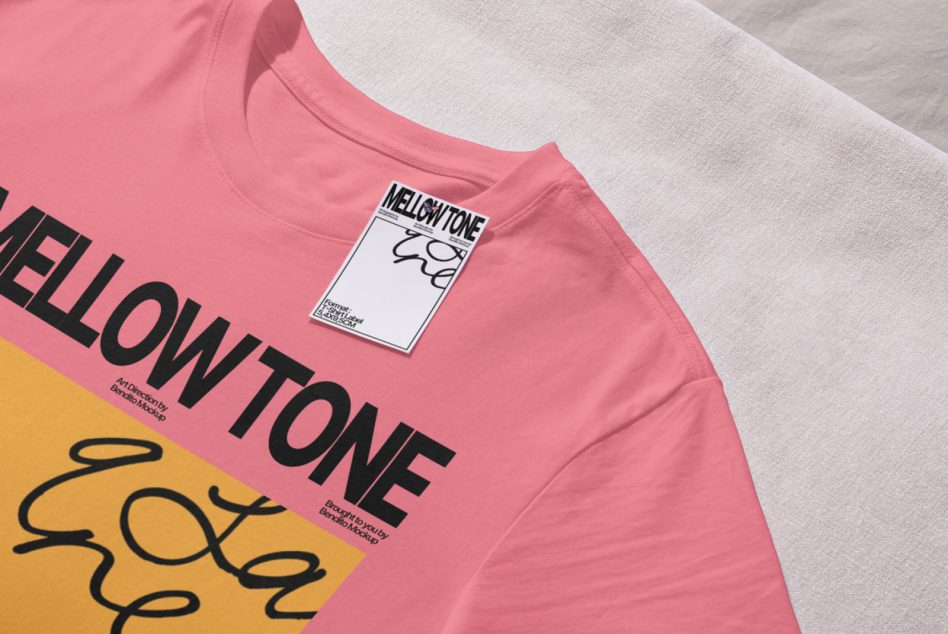 Pink tee with mellow tone branding, white label tag, yellow graphic detail