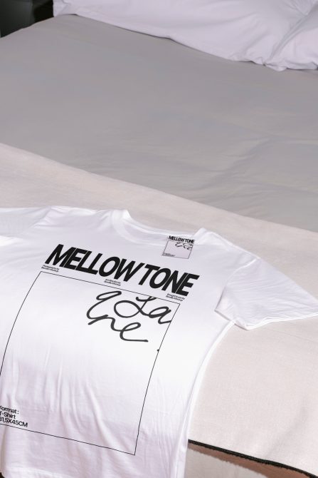 White t-shirt mockup with black text design on a bed, high-resolution apparel template for print and graphic display.