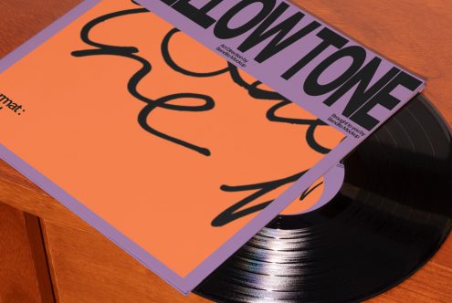 Vinyl record cover mockup with modern typography, vibrant orange background on a wooden surface for graphic design showcase.