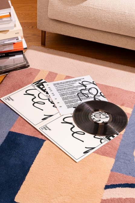 Vinyl record and magazine mockup on colorful rug with modern fonts for music and editorial design projects, showcasing stylish interior setting.