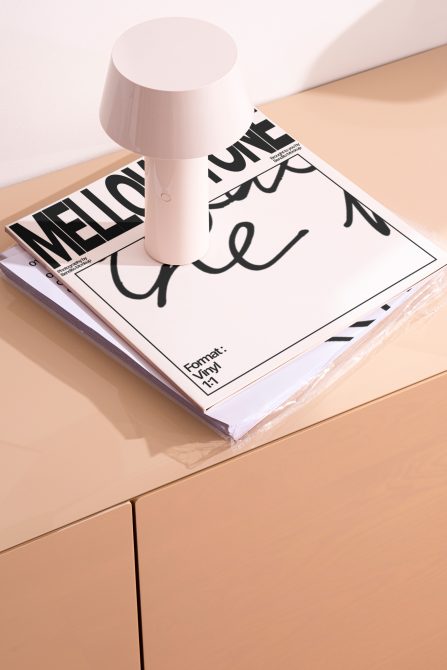 Modern lamp on magazine mockup with typography design, showcasing lighting and print presentation on a wooden surface for interiors.