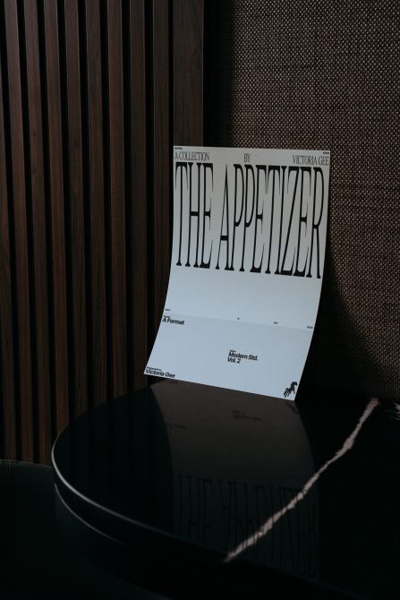 Magazine cover mockup leaning against textured wood with bold serif headline