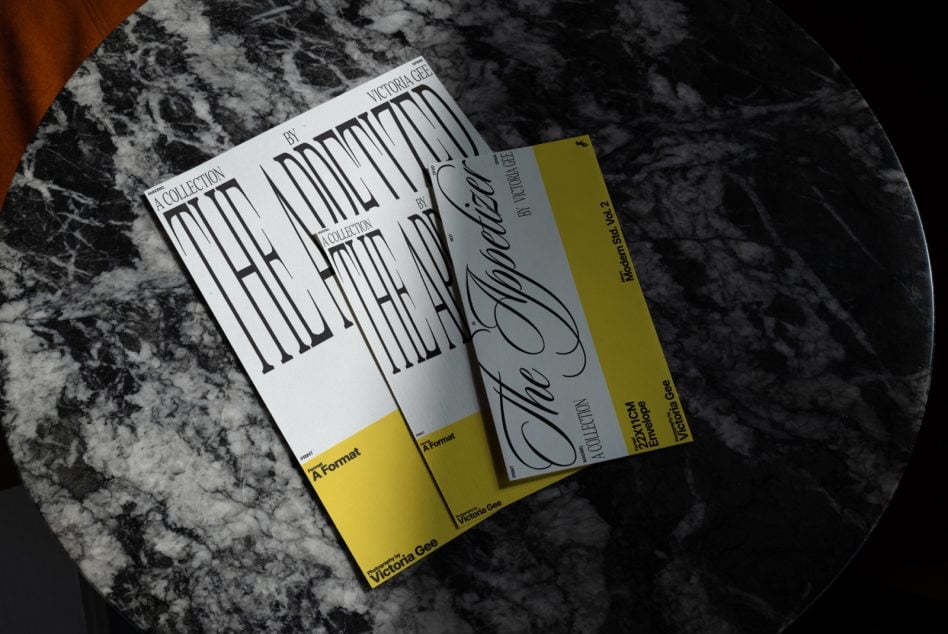 Three print items fanned on marble with yellow banding, modern serif typeface
