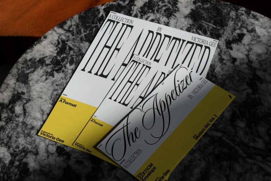 Stacked print mockups with bold striped typography, yellow accents on marble table