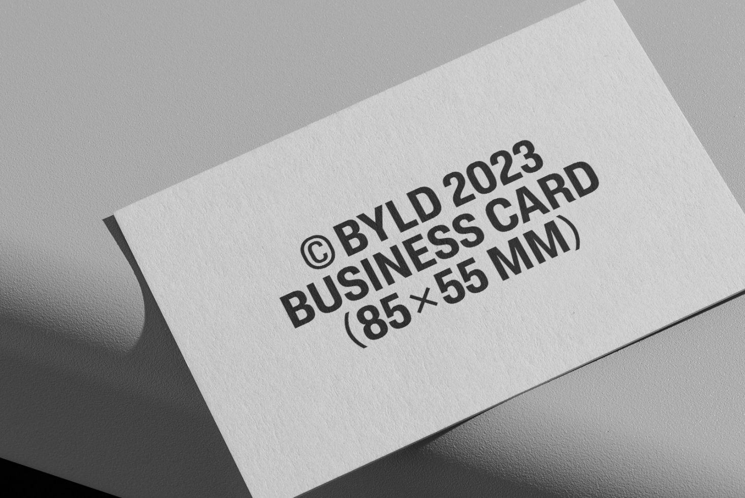 Business card mockup with simple text layout, black on white design, 85x55mm, isolated on a gray background, showcasing modern typography.