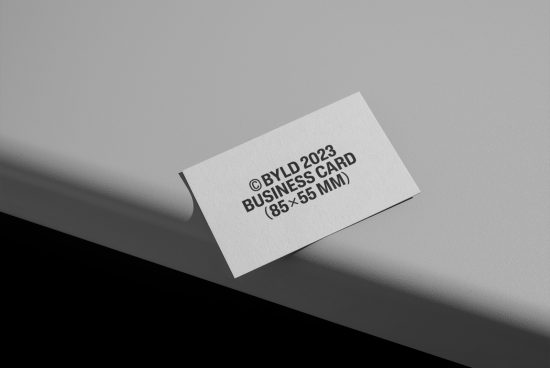 Minimalist business card mockup lying on a smooth surface with soft shadows, showcasing front design, perfect for branding presentations.