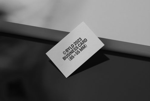 Elegant business card mockup on a dark, sleek surface with contrasting shadows, ideal for presentations and branding designs.