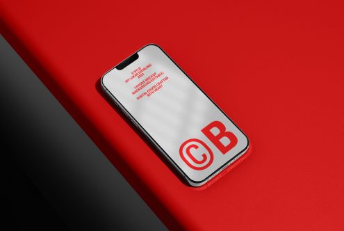 Smartphone mockup on red background for product design presentation, showcasing logo and screen design, ideal for digital asset portfolio.