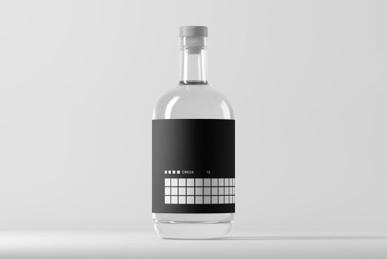 Clear glass bottle with minimalist black label design mockup on a grey background, ideal for branding and packaging presentations.