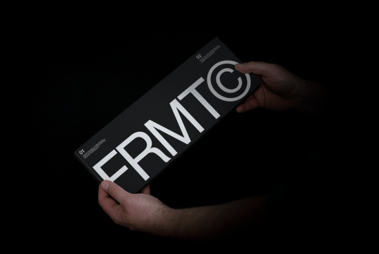 Close-up perspective of hands holding a sleek font presentation mockup with bold typography design on a dark background for branding.