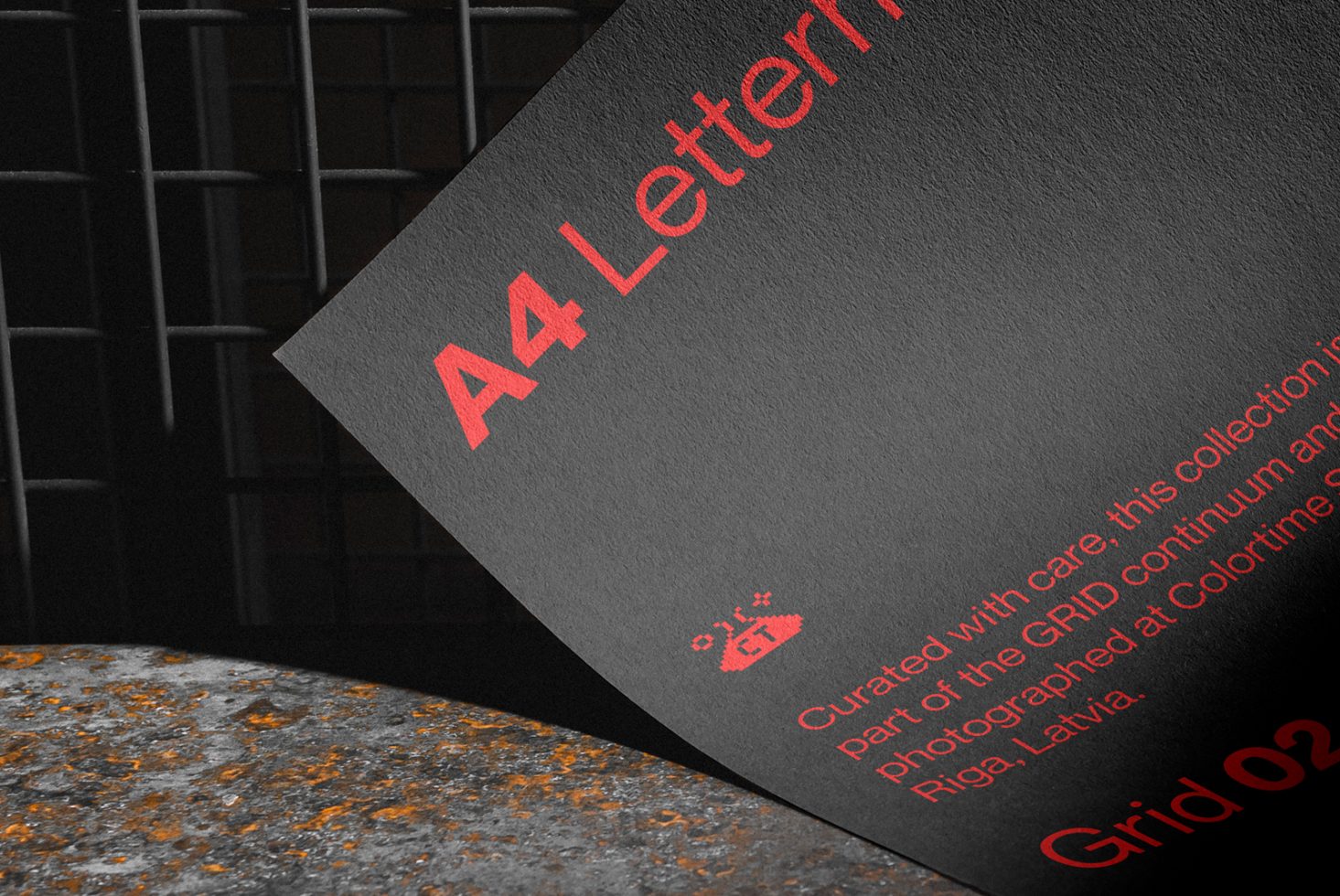 Mockup of A4 letterhead with red print on black paper, realistic texture and background, designer stationery presentation.