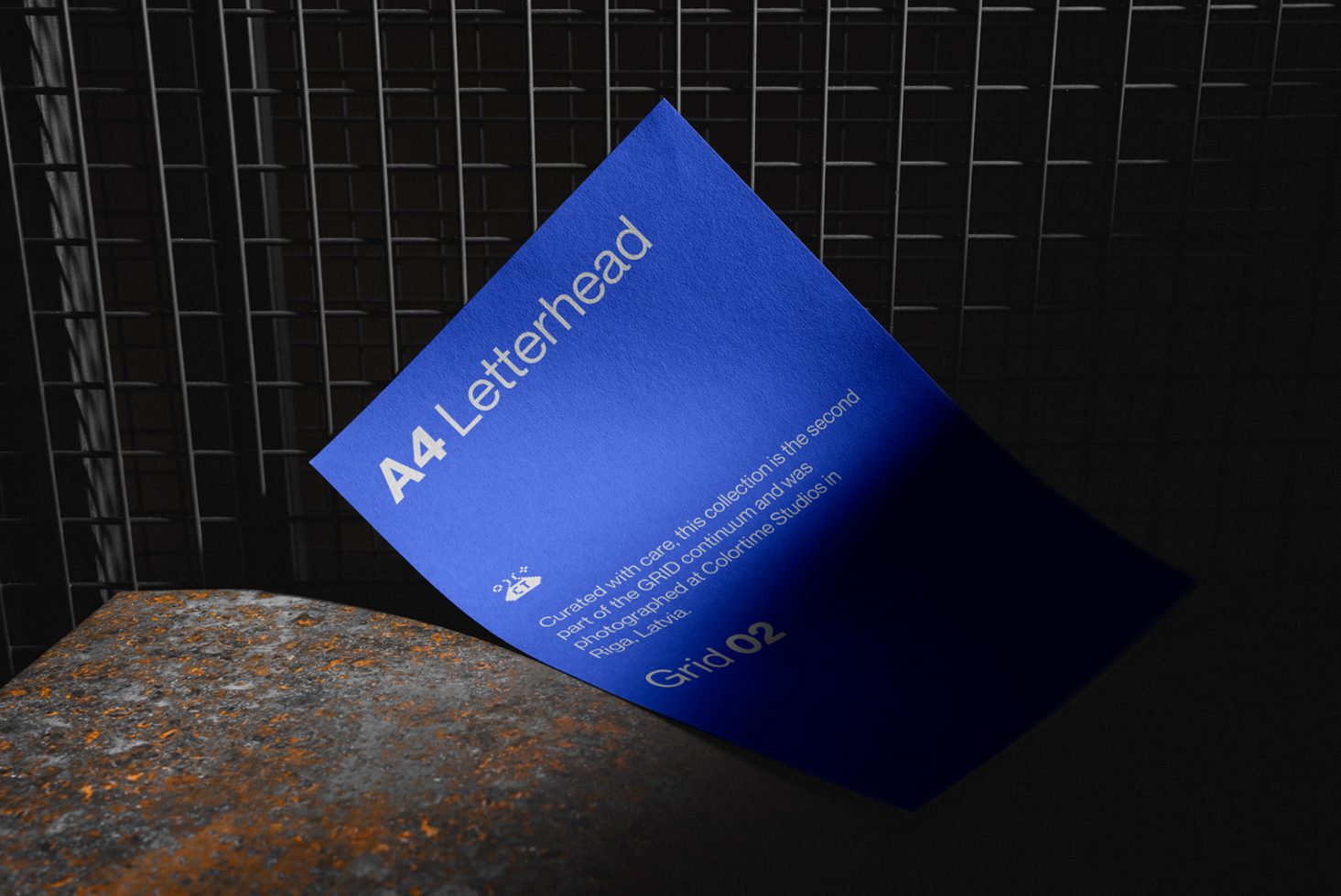 Blue A4 letterhead mockup on textured surface with shadow grid pattern background, realistic branding design presentation.