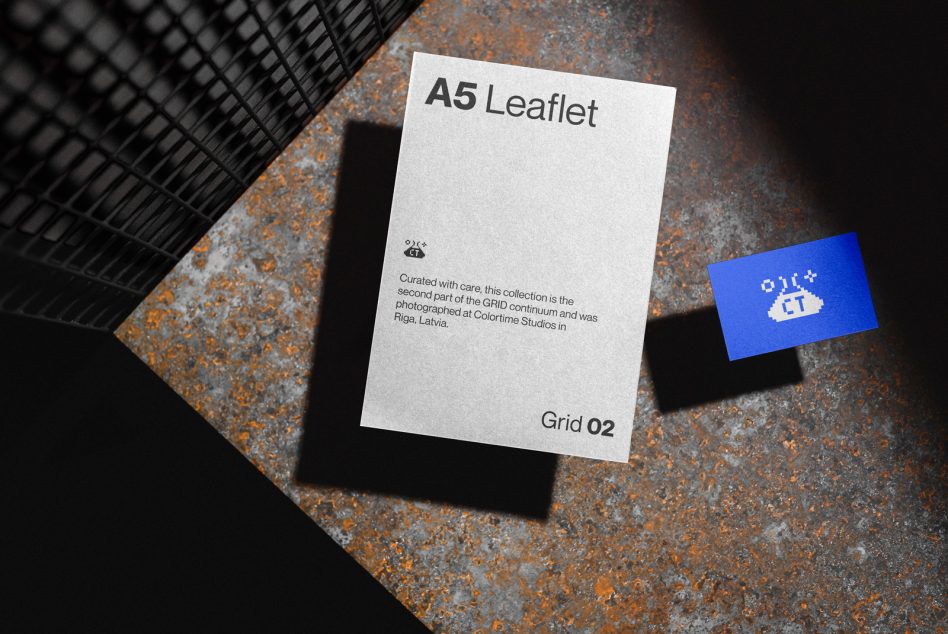 White A5 leaflet with bright blue business card on rusty surface