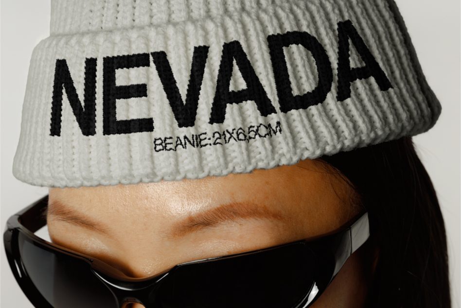 Close-up of a stylish beanie mockup on a model with bold NEVADA text, ideal for fashion designers to showcase their branding designs.