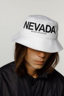Model wearing white Nevada bucket hat with black shirt, head down