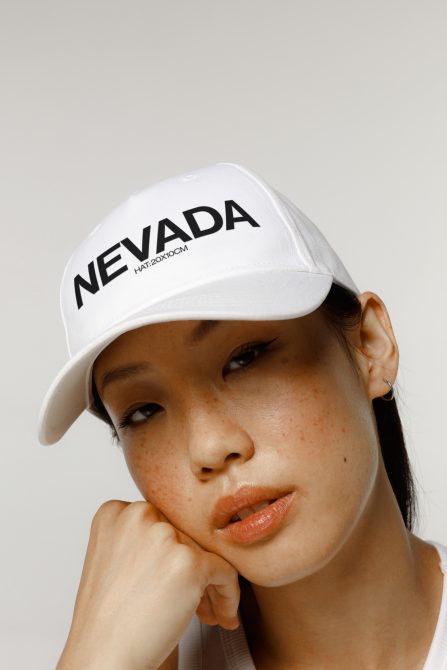 Close-up of a model wearing a white cap with text, perfect for apparel mockups, showcasing hat designs, and fashion accessories.