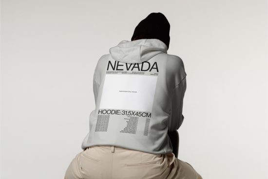 Person wearing hoodie mockup with graphic design, rear view, in neutral tones for fashion template.